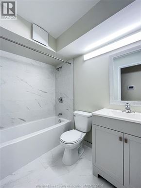 Windsor apartment for rent - A white toilet sits next to a sink in a bathroom.