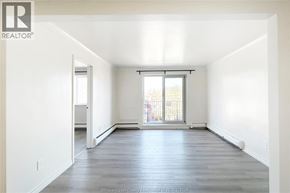Windsor apartment for rent - A spacious empty room with a large window and wooden flooring.