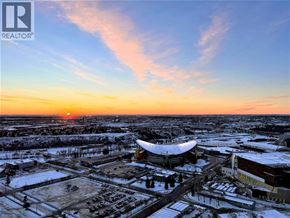For rent in Calgary - A sunset view of a snowy landscape with a large building in the foreground.