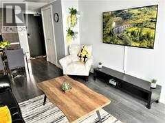 Calgary other for rent - A living room with a couch, a coffee table, and a large painting on the wall.