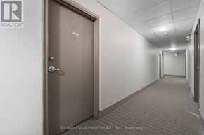 Hamilton (Durand) multi-family for rent - A hallway with a brown door and a brokerage logo.