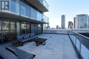 Toronto (Church-Yonge Corridor) condo for rent - A balcony with a couch and a table is shown with the words "COMFREE, Brokerage" in the foreground.