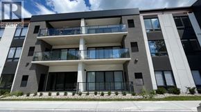 Kingsville condo for rent - A modern apartment building with a balcony and a garden in front.
