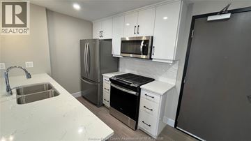 Kingsville condo for rent - A kitchen with white cabinets and a sink.