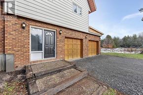 For rent in Ottawa - A house with a gravel driveway and two garage doors.