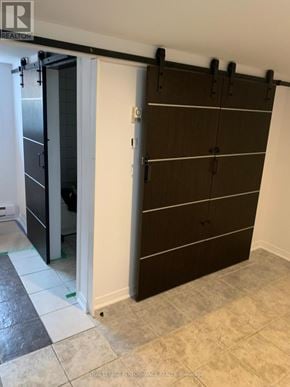Casselman house for rent - A brown wardrobe with black handles is in a room with a white door.
