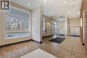 Hamilton condo for rent - A hallway with a window showing trees outside and a door at the end.