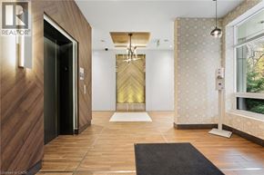 Hamilton condo for rent - A hallway with a black door and a wooden floor.