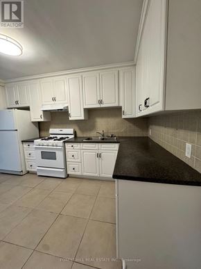 Toronto (Annex) house for rent - A kitchen with white cabinets and appliances.