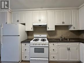 Toronto (Annex) house for rent - A kitchen with white cabinets and appliances.