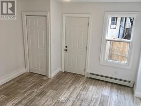 St. Catharines (Downtown) house for rent - A room with two doors and a window with a wooden frame.