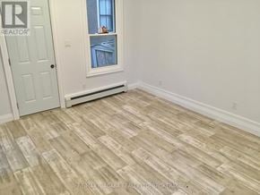 St. Catharines (Downtown) house for rent - A room with a wooden floor and a window.