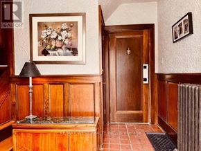 Toronto (High Park North) house for rent - A hallway with a wooden door and a framed picture on the wall.