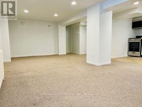 Toronto (High Park North) house for rent - A large, empty room with a carpeted floor and white walls.