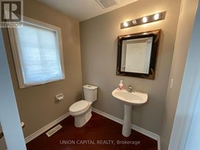 Markham (Wismer) house for rent - A bathroom with a toilet, sink, and mirror.