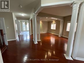 Markham (Wismer) house for rent - A spacious room with wooden floors and white columns.