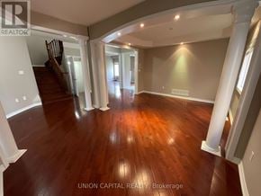 Markham (Wismer) house for rent - A spacious room with wooden floors and white walls.