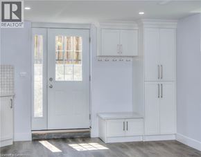 Kitchener house for rent - A white interior with a door, cabinets, and a bench.