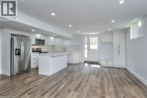 Kitchener house for rent - A modern kitchen with wooden floors and white cabinetry.