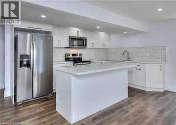 Kitchener house for rent - A modern kitchen with a stainless steel refrigerator and white countertops.