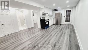 Mississauga (Fairview) house for rent - A kitchen area with a refrigerator, oven, and cabinets.