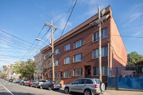 Jersey City apartment for rent - a large brick building with cars parked in front of it
