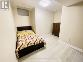 Ajax (Northwest Ajax) house for rent - A bedroom with a bed, dresser, and light fixture.