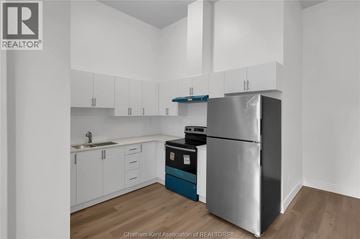 Dresden apartment for rent - A kitchen with white cabinets and a stainless steel refrigerator.