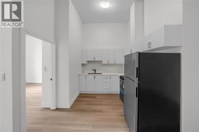 Dresden apartment for rent - A kitchen with white cabinets and a black refrigerator.