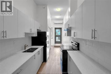 Dresden apartment for rent - A modern kitchen with white cabinets and a black refrigerator.