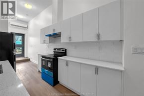 Dresden apartment for rent - A kitchen with white cabinets and a black fridge.