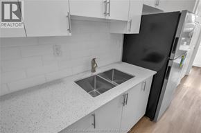 Dresden apartment for rent - A kitchen with white cabinets and a black refrigerator.