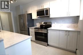 Kitchener apartment for rent - A kitchen with white cabinets and a marble countertop.