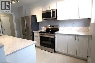 Kitchener apartment for rent - A kitchen with white cabinets and a marble countertop.