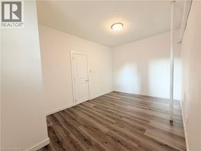 Hamilton apartment for rent - A room with wooden flooring and a white door.
