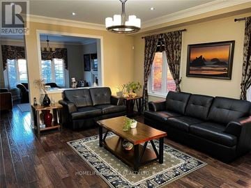 Brampton (Brampton West) house for rent - A living room with a black leather couch and a coffee table.