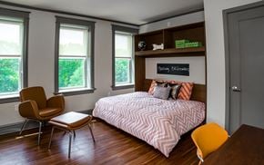 St. Louis apartment for rent - A bedroom with a bed, chair, and window.