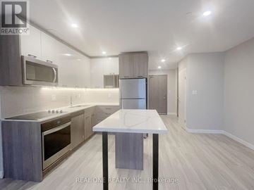 Hamilton (Central) condo for rent - A modern kitchen with a table in the middle of the room.