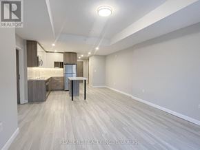 Hamilton (Central) condo for rent - A spacious room with a dining table and chairs in the foreground and a kitchen area in the background.