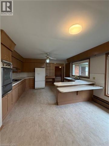 Stoney Creek house for rent - A kitchen with wooden cabinets and a white fridge.