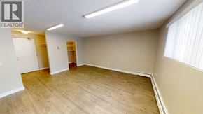 For rent in Grande Prairie - A room with wooden flooring and a white ceiling with a light fixture.