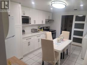 Oakville (Mo Morrison) house for rent - A white kitchen with a table and chairs.