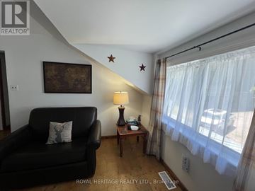 For rent in Tudor And Cashel (Tudor Ward) - A living room with a black couch, a lamp, and a painting on the wall.