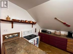 For rent in Tudor And Cashel (Tudor Ward) - A kitchen with a stove top oven and a microwave on a counter.