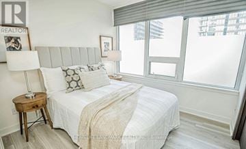 Toronto (Waterfront Communities) condo for rent - A bedroom with a large bed and a window with blinds.