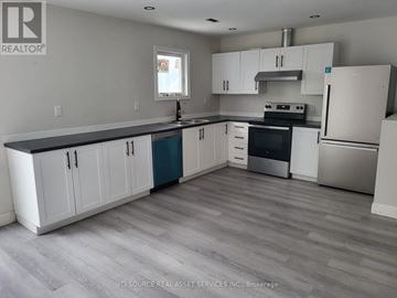 Niagara Falls (Dorchester) house for rent - A kitchen with white cabinets and a grey floor.
