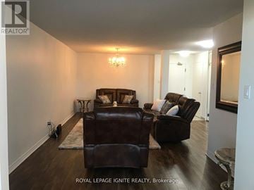 Toronto (Rouge) condo for rent - A living room with a brown leather couch and ottoman.