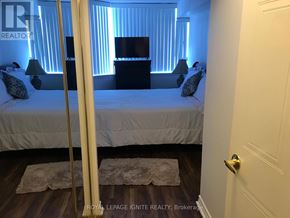 Toronto (Rouge) condo for rent - A bedroom with a bed, nightstand, and lamp.