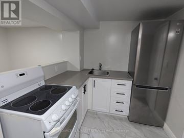 Niagara Falls (Dorchester) house for rent - A kitchen with white appliances and cabinets.