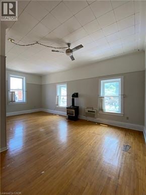 Paris apartment for rent - A room with a ceiling fan and wooden floors.